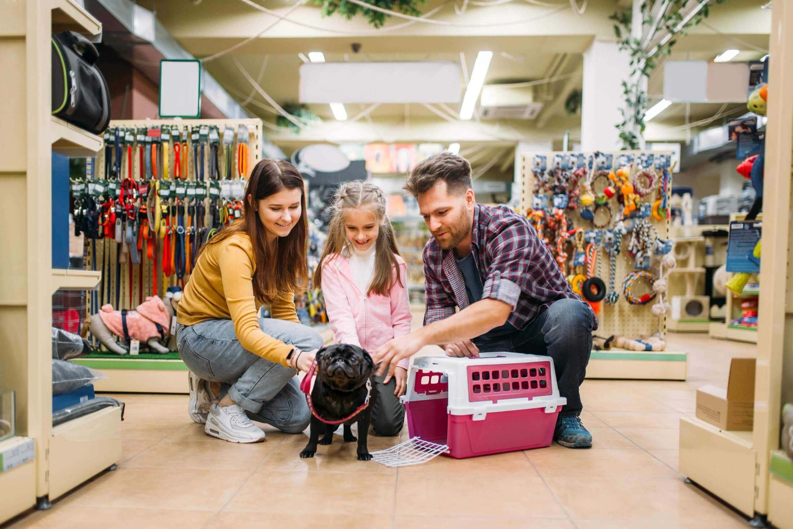 A family joyfully interacts with their dog while exploring a pet store filled with various pet supplies highlighting pet store loyalty programs benefits