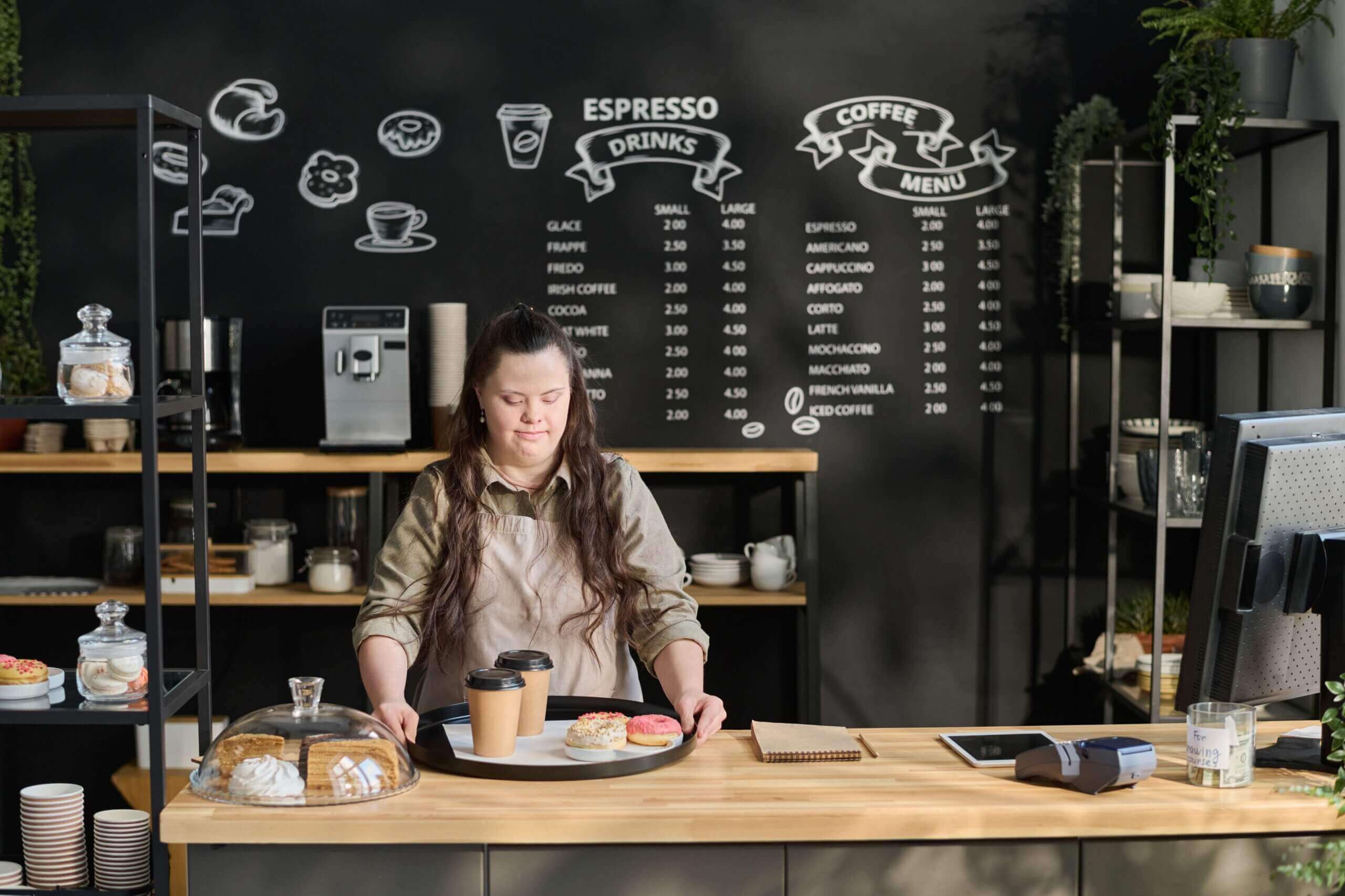 Two servings of coffee cups and donuts neatly arranged on a table for dining in